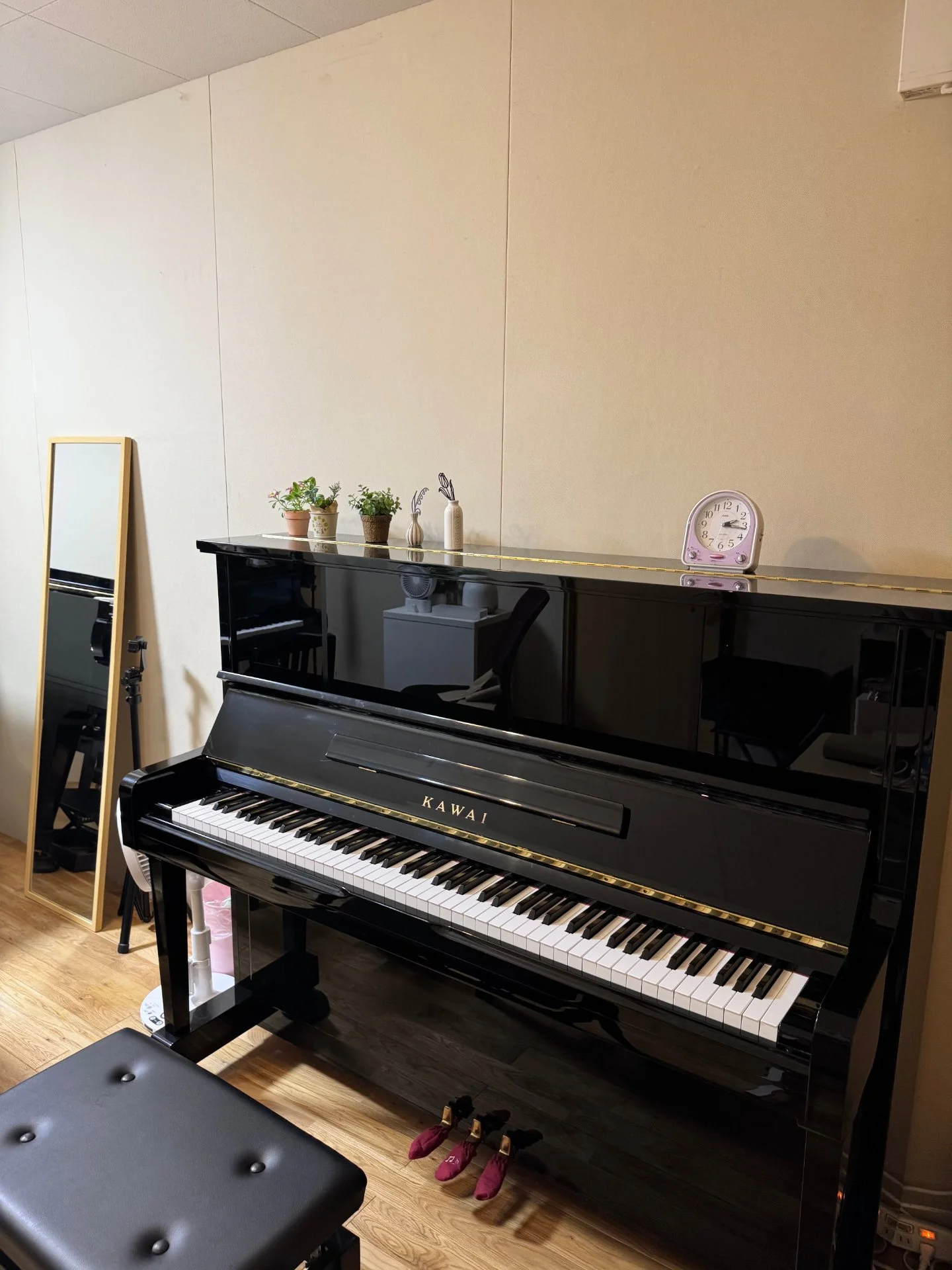 教室の棚に並んだ絵本と音符カード、壁に子どもの作品が飾られている一角
