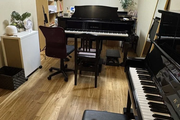教室の棚に並んだ絵本と音符カード、壁に子どもの作品が飾られている一角