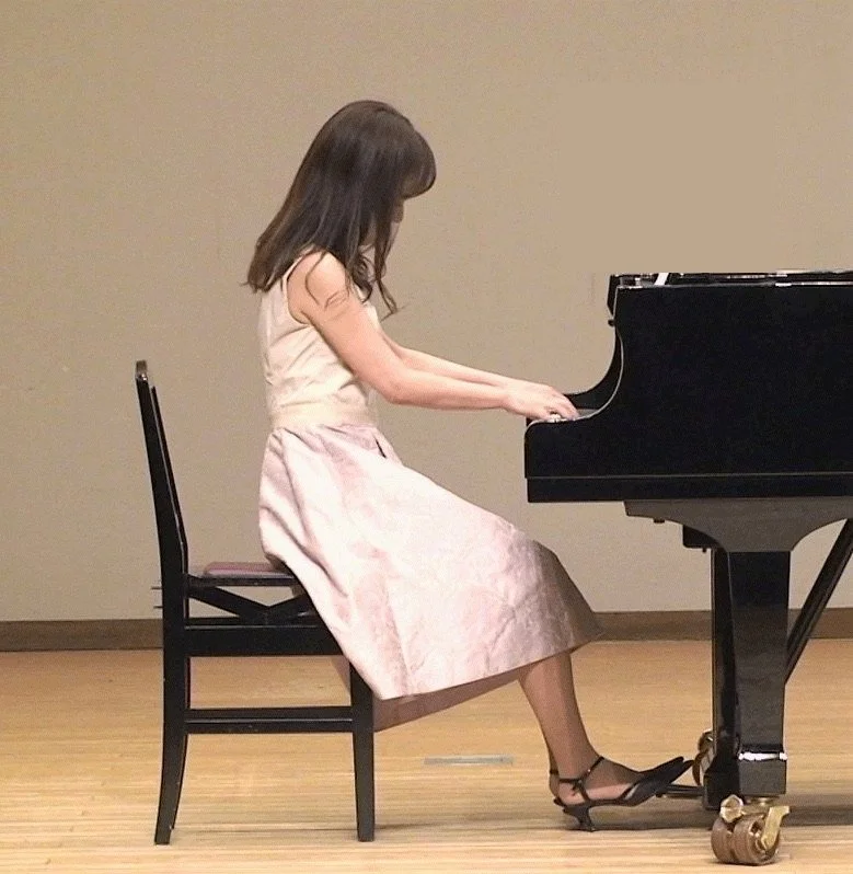 ステージでグランドピアノを演奏する先生の横顔