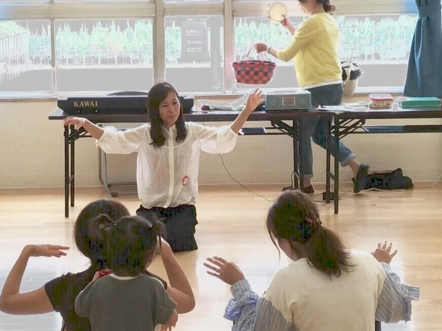 子どもがアップライトピアノの前に座り、先生が横で楽譜を指しながら音を確かめている場面