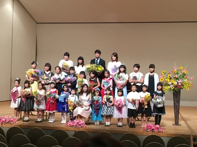 広い部屋で先生が床にテープで線を引き、子どもたちがリズムに合わせて歩いている出張レッスンの様子